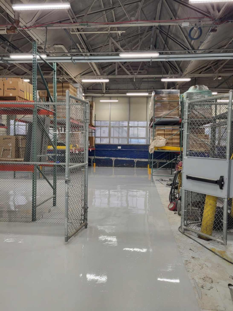 photo of a warehouse floor with a gate. The floor is shiny and has been encapsulated 